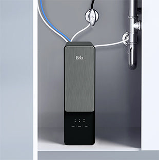 A sleek, modern water filtration system installed under a kitchen sink, with blue and white tubes connected to plumbing pipes, and a metallic front panel displaying indicator lights.